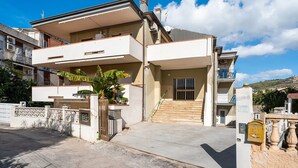 A modern two-story residential building with a concrete driveway, a gated entrance, and a staircase leading to the entrance. - Apartment 'Ponente' with Sea View, Wi-Fi and Air Conditioning (Agropoli)
