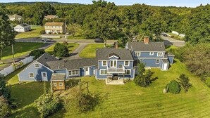 A large, two-story house with a spacious front yard, a driveway, and a small garage.