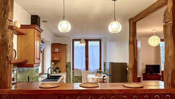 A kitchen with wooden cabinets, a sink, and two hanging pendant lights. - 1 bedroom amazing home in Nanteuil-en-Vallée (Nanteuil-en-Vallée)