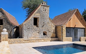 Un edificio de piedra con piscina delantera.