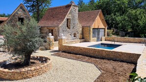 A stone building with a swimming pool, surrounded by gravel and trees. - Superbe maison avec piscine (Montgesty)