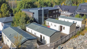 A cluster of modern cabins with metal roofs, surrounded by trees and rocky terrain. - Beautiful home in Göteborgs with WiFi (Göteborgs)