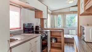 A compact kitchen with a stove, sink, and wooden cabinets. - Beautiful home in Göteborgs with WiFi (Göteborgs)