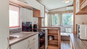 A compact kitchen with a stove, sink, and wooden cabinets. - 2 bedroom lovely home in Göteborgs (Göteborgs)