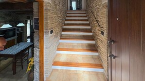 A stone-walled staircase with wooden steps leading to a door.