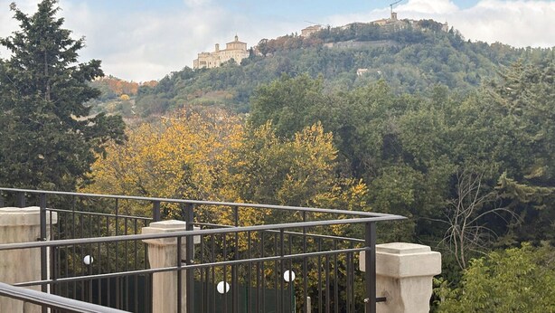 A view of a hilltop building surrounded by trees.