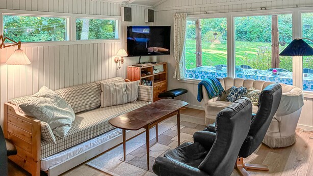 Ein gemütliches Wohnzimmer mit einer Couch, einem Couchtisch, einem Fernseher und einem Bücherregal.
