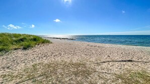 Una playa arenosa con cielo despejado y mar tranquilo.