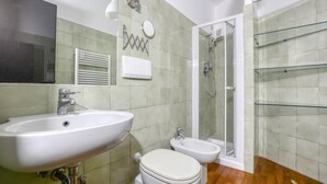 A bathroom with a sink, toilet, bidet, and glass shower enclosure. - Cozy apartment in Bogliasco with WiFi (Bogliasco)