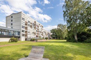 A modern building with a flat roof, large windows, and a paved walkway. - Apartment 'Steuermann am Steinhuder Meer' with Balcony (Wunstorf)