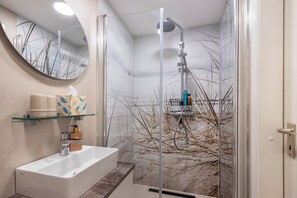 A modern bathroom with a glass shower enclosure, a white sink, and a mirror. - Apartment 'Steuermann am Steinhuder Meer' with Balcony (Wunstorf)
