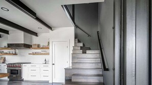 A modern kitchen with white cabinetry, a built-in oven, and a wooden countertop.