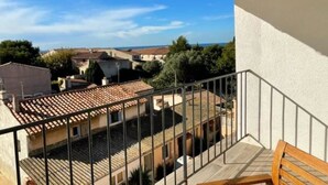 Un balcon avec vue sur la ville et la mer.