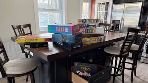 Keittiössä on puinen keittiösaareke, tuoleja ja monenlaisia lautapelejä.