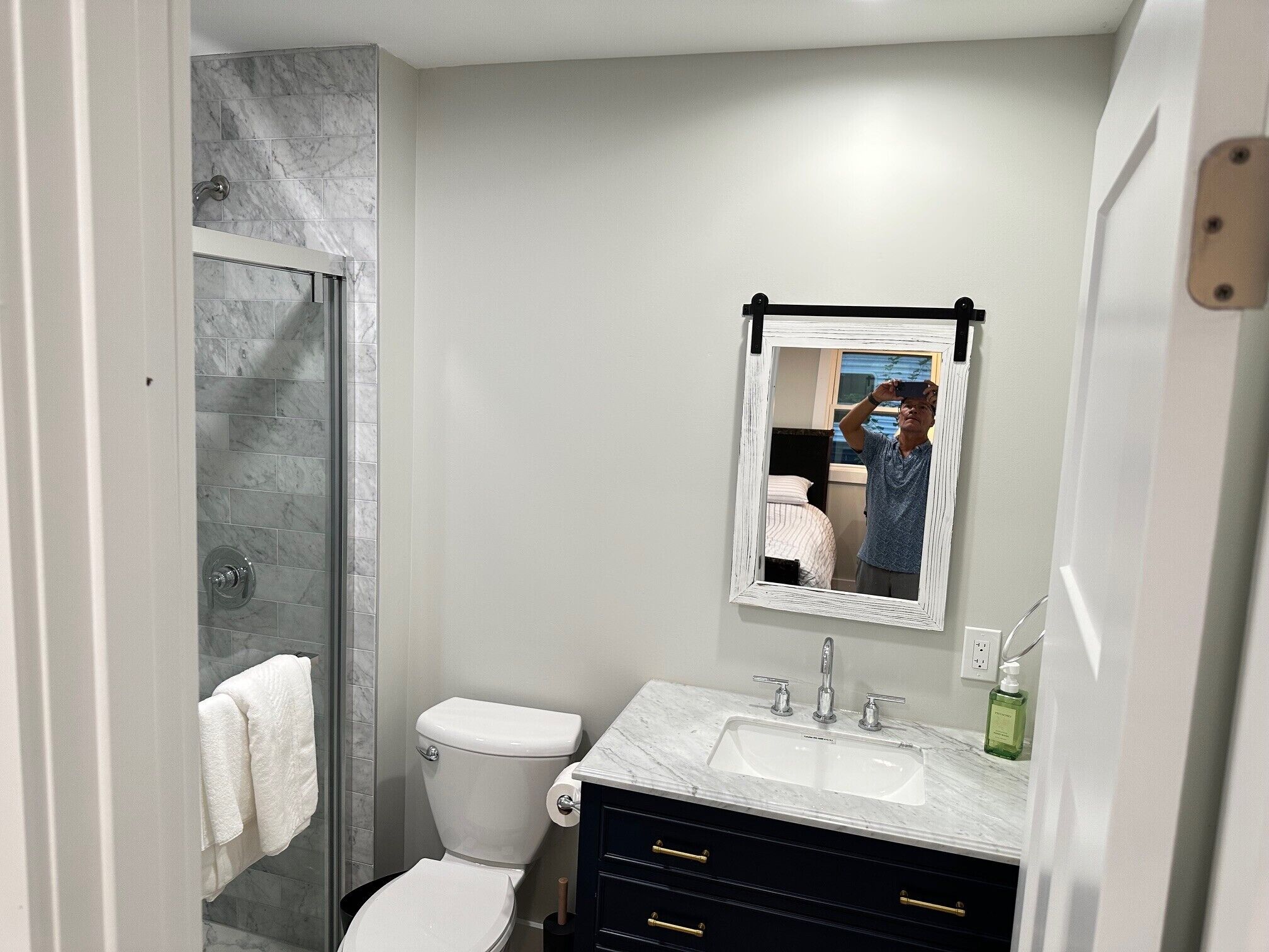 Une salle de bain équipée d’une douche, de toilettes, d’un lavabo et d’un miroir.