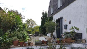 A garden with potted plants and a bench. - Natural paradise at the gateway to the Ruhr area: Idyllic temporary home on the Heierberg (Hattingen)