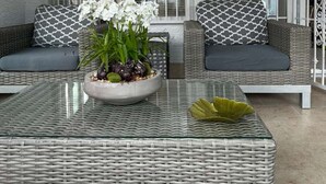 A modern outdoor seating area with wicker furniture and a glass coffee table. - 3BR/3BA w/ Pool & BBQ • 15 Mins to Strip & Airport (Las Vegas)