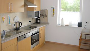 Eine moderne Küche mit eingebautem Backofen, Mikrowelle und Spüle aus Edelstahl.