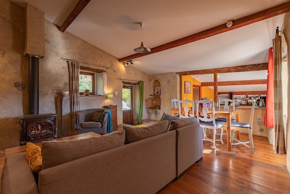 A cozy living room with a sofa, wooden floor, and a fireplace.