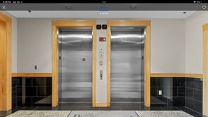 An elevator with a metallic finish, a control panel, and a sign that reads "The Paramount." - Long term stay Exquisite penthouse apartment in Raleigh. (Raleigh)