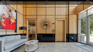 A modern lobby with a sofa, coffee table, and abstract art on the wall. - Long term stay Exquisite penthouse apartment in Raleigh. (Raleigh)