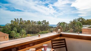 A balcony with a wooden table, two striped cups, and a chair. - Apartment 'Ocean View Dunas De Artola' with Sea View, Wi-Fi and Air Conditioning (Marbella)