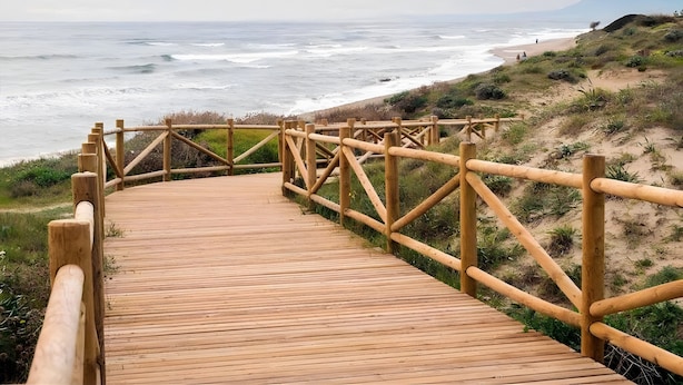 A wooden boardwalk leading to a beach with ocean views. - Apartment 'Ocean View Dunas De Artola' with Sea View, Wi-Fi and Air Conditioning (Marbella)