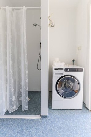 Regadera, secadora de cabello, toallas, papel de baño 