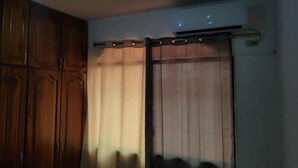 A room with wooden cabinets and a curtain rod with a light fixture. - Pacific Paradise in Ecuador (Manta)