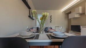 A dining area with a table set for two, featuring modern decor and a vase with flowers. - Casa di Leonardo by Wonderful Italy (Turin)