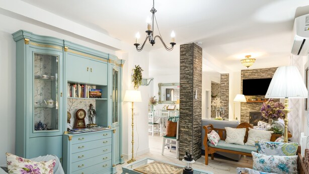Een woonkamer met een bank, salontafel, boekenplank en een televisie.