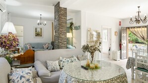 Een woonkamer met een bank, een glazen tafel en uitzicht op het omliggende landschap.