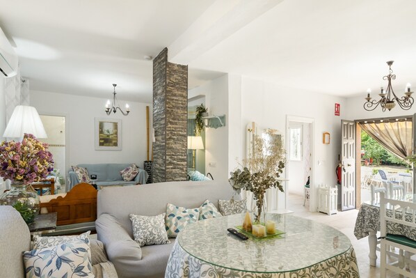A living room with a sofa, a glass table, and a view of the outside.