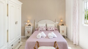 Een slaapkamer met een bed, twee nachtkastjes, een kledingkast en een raam met gordijnen.