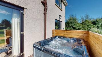 A hot tub in a wooden enclosure with a clear view of the surrounding area.