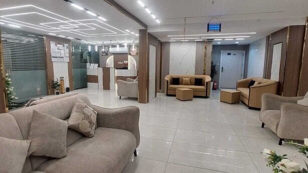 A modern hotel lobby with sofas, a reception desk, and a reception area. - City Luxury Serviced Apartments (Madinah)