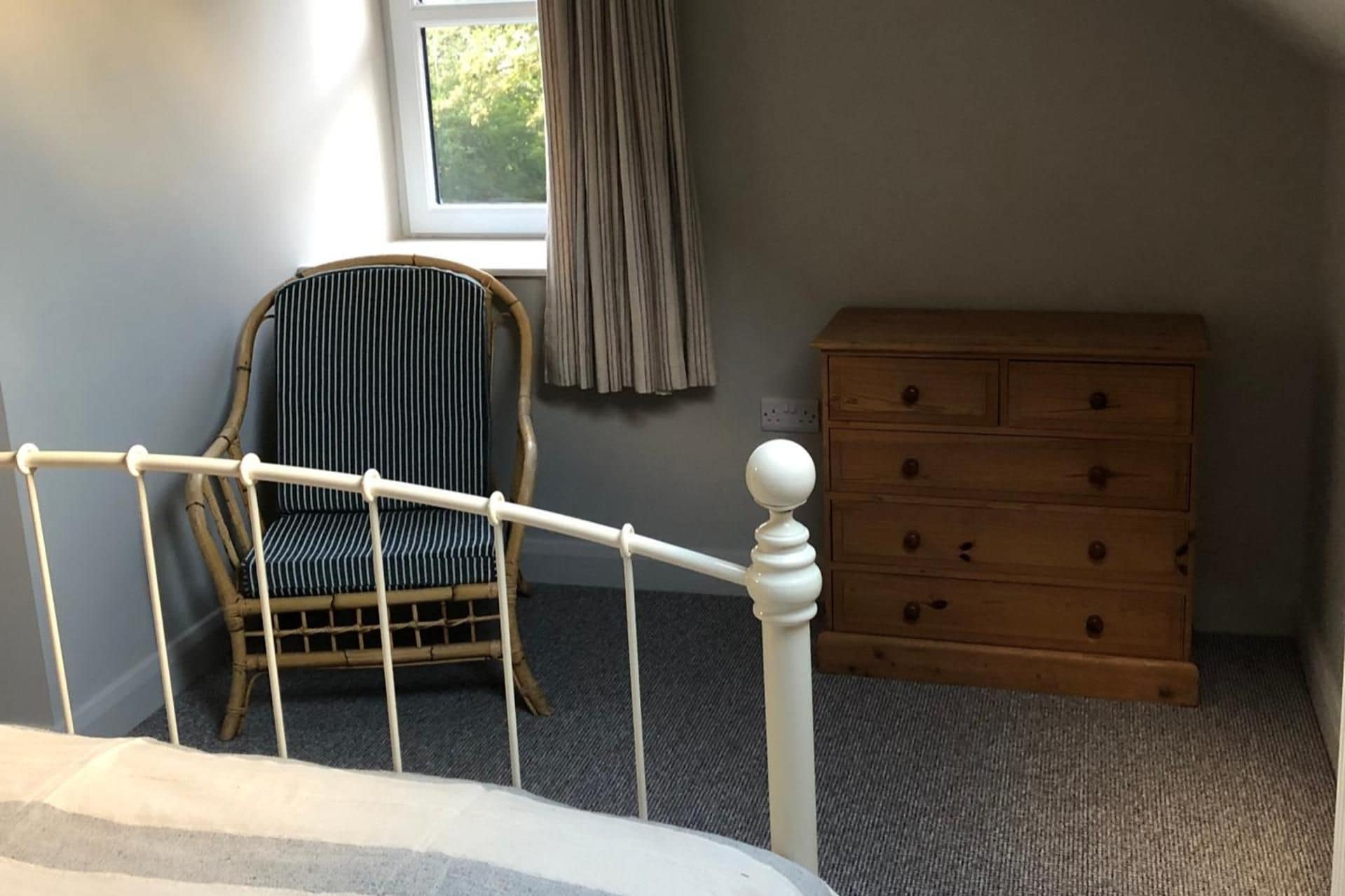A room with a bed, a chair, and a dresser.