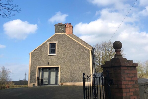 A two-story stone building with a gabled roof, a small window, and a brick entrance. - Apartment Bushmills Hideaway, Parking,pets Allowed (Bushmills)