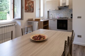 Une cuisine moderne avec une table en bois, un bol de nourriture et une fenêtre donnant sur un paysage verdoyant.