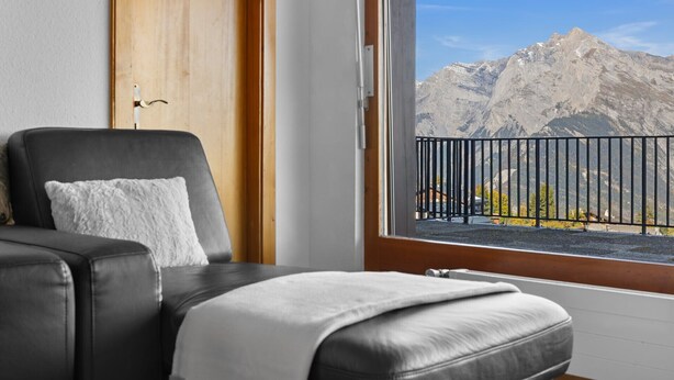 Une chambre avec vue sur les montagnes, accessible par un balcon.