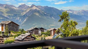 Une station de montagne composée de plusieurs bâtiments de style chalet, offrant une vue sur les sommets environnants.
