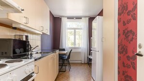 A compact kitchen with a stove, microwave, and a dining area with a table and chairs.