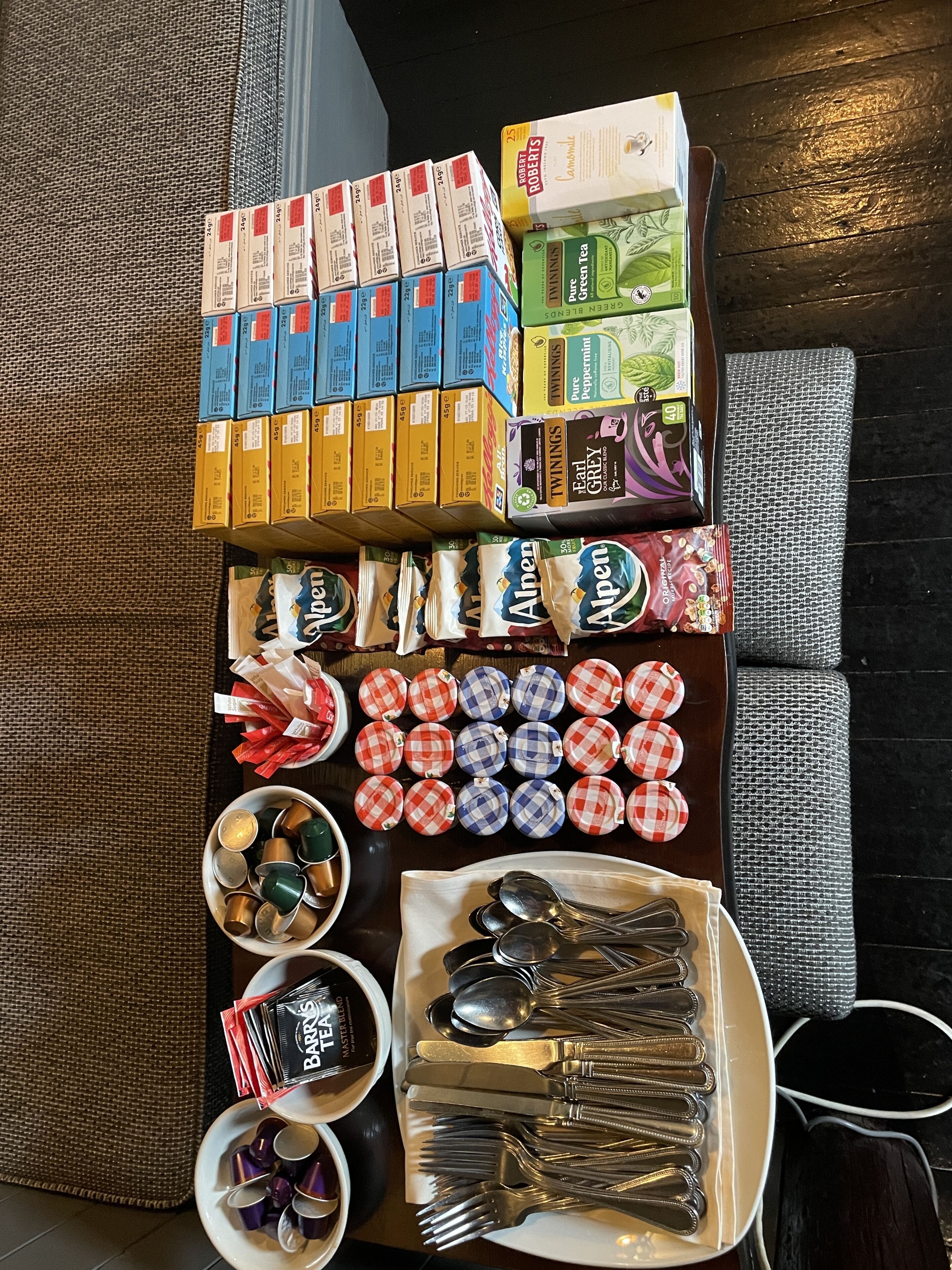 Variedad de productos envasados, como té, aperitivos y cubiertos, sobre una mesa.