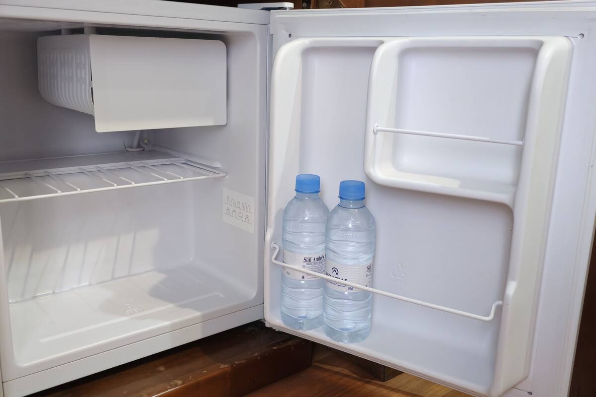 An open refrigerator with two water bottles and a carton of milk.