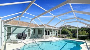 A covered swimming pool with lounge chairs and a barbecue grill. - Sunset Pines, Sleeps 6, heated pool, 2 Dog ok (Rotonda West)