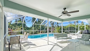 A covered patio with a pool, outdoor furniture, and a ceiling fan. - Sunset Pines, Sleeps 6, heated pool, 2 Dog ok (Rotonda West)