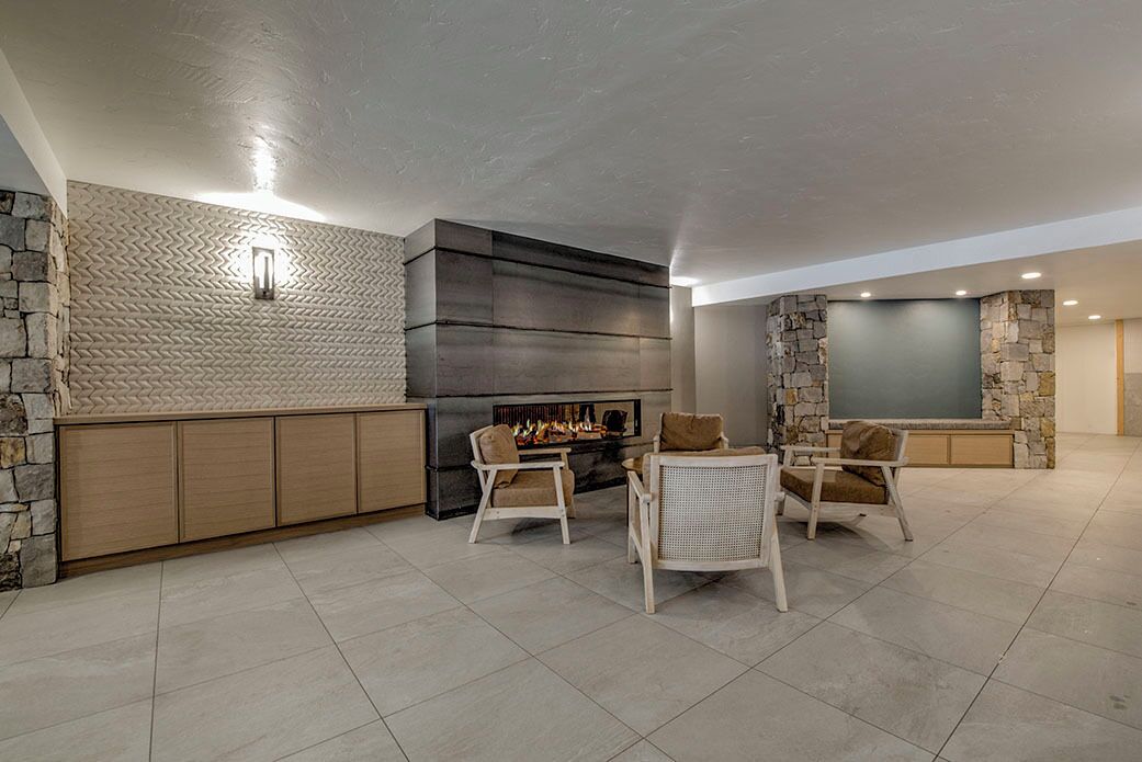 A spacious living area with a fireplace, stone accents, and comfortable seating.