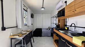 A compact kitchen with a dining area, a microwave, a kettle, and a sink. -  Residencial Taulois Canela Centro (Canela)