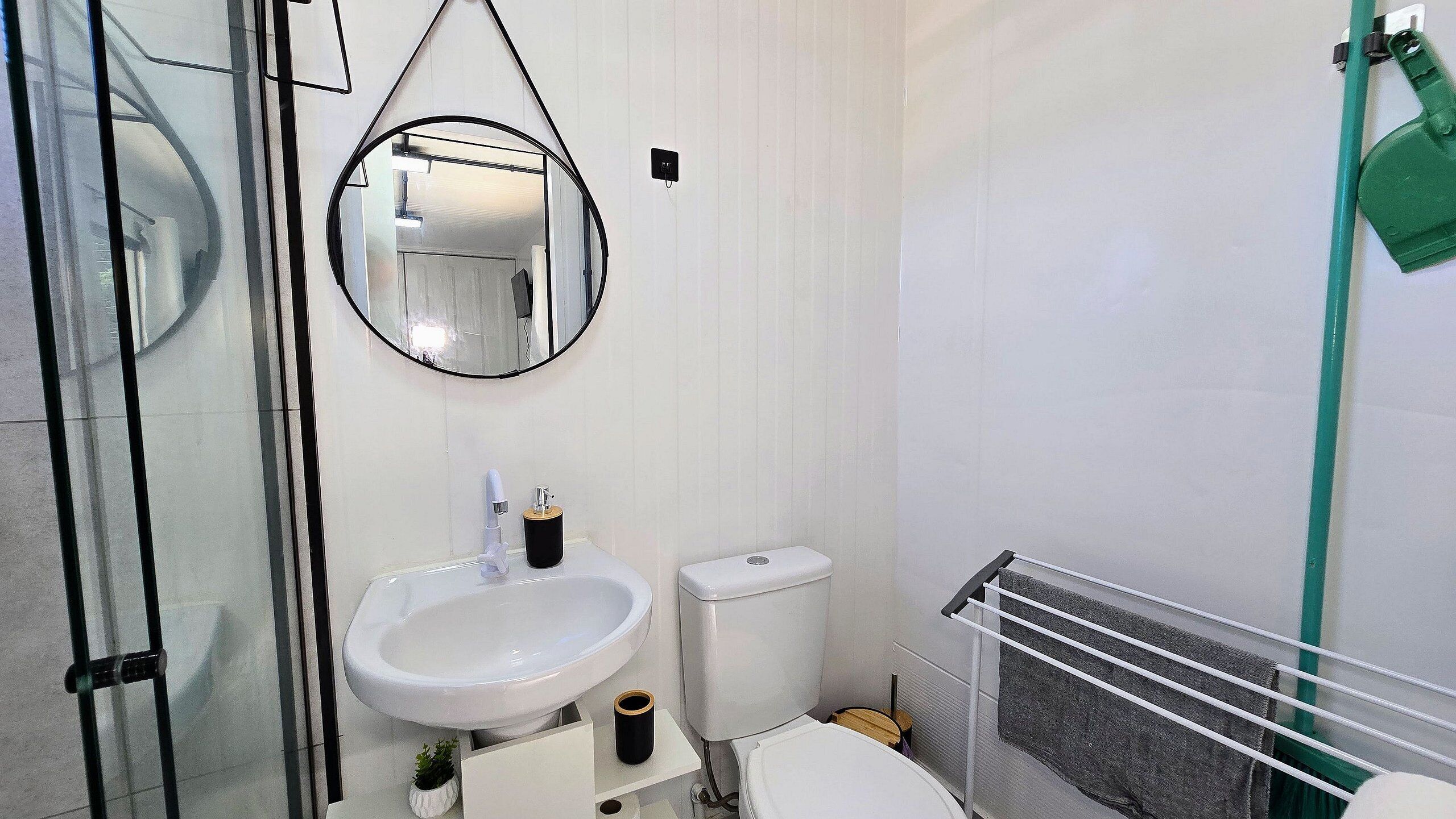 A bathroom with a sink, toilet, and a mirror.
