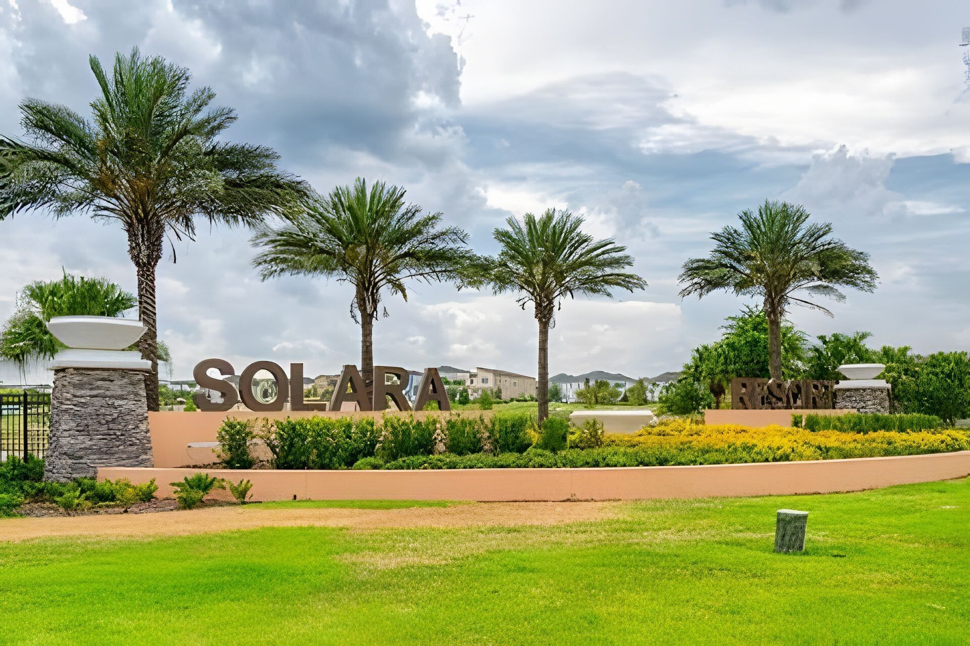 A resort entrance with palm trees, a stone pathway, and a sign reading "SOLAR RESORT".
